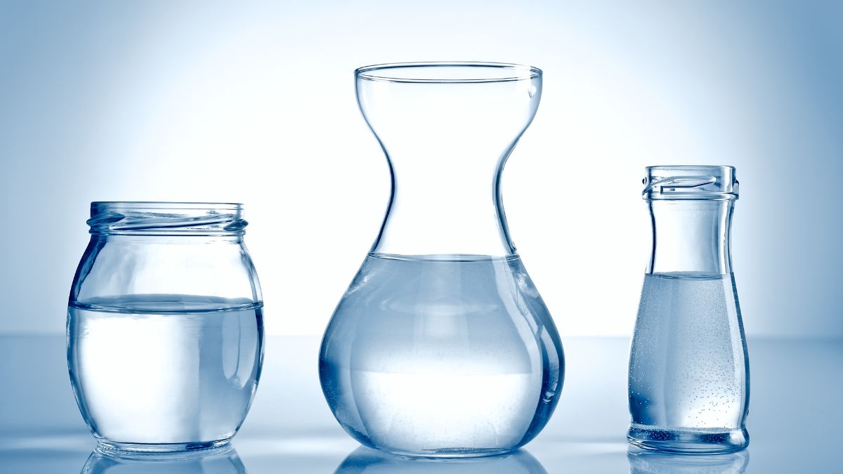 Trois récipients en verre contenant de l'eau claire, symbolisant l'hydratation.