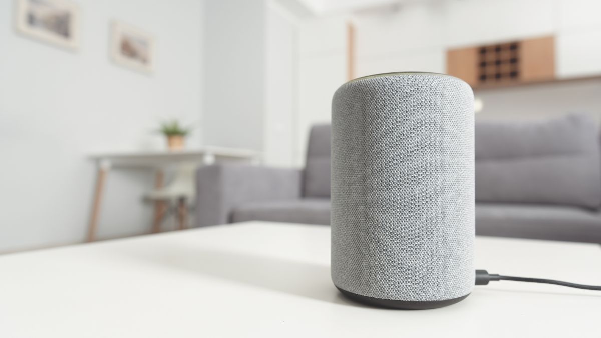 Une enceinte moderne grise sur une table, prête à diffuser de la musique.