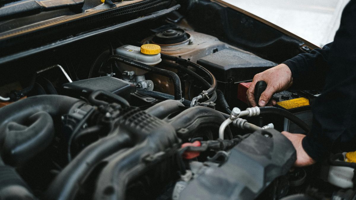 Un mécanicien inspecte le moteur d'une voiture, vérifiant les composants internes.