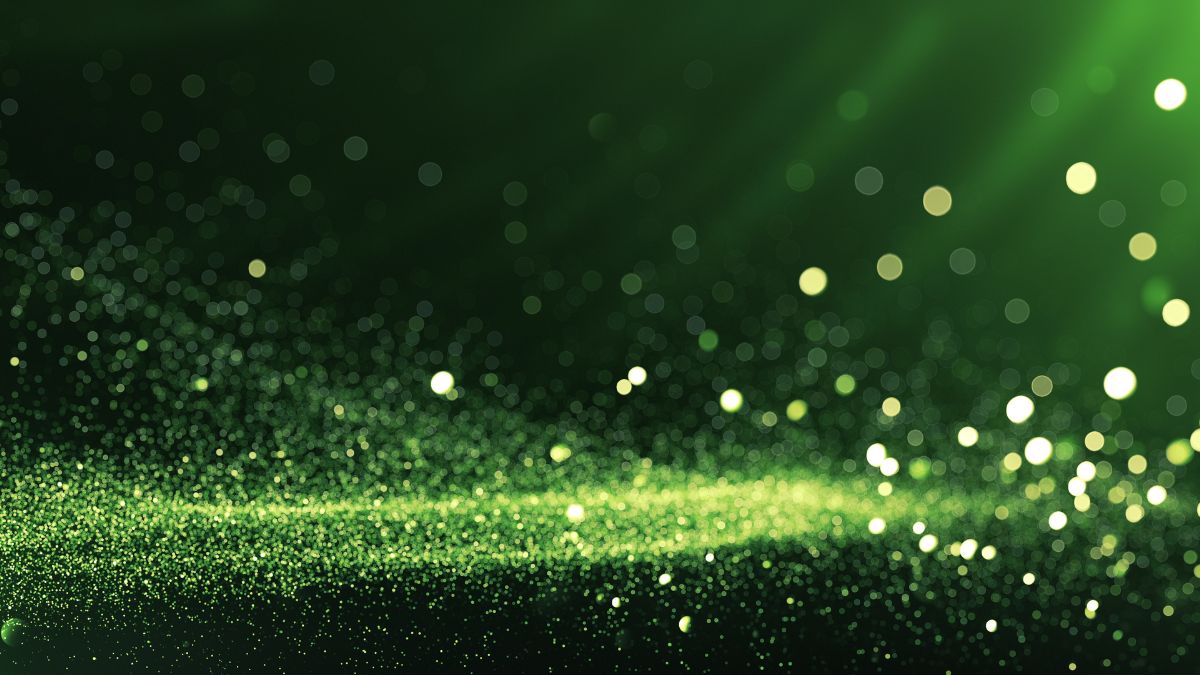 Fond vert : fonctionnement de la technologie et applications Un fond vert avec des particules scintillantes, idéal pour le keying en vidéo.