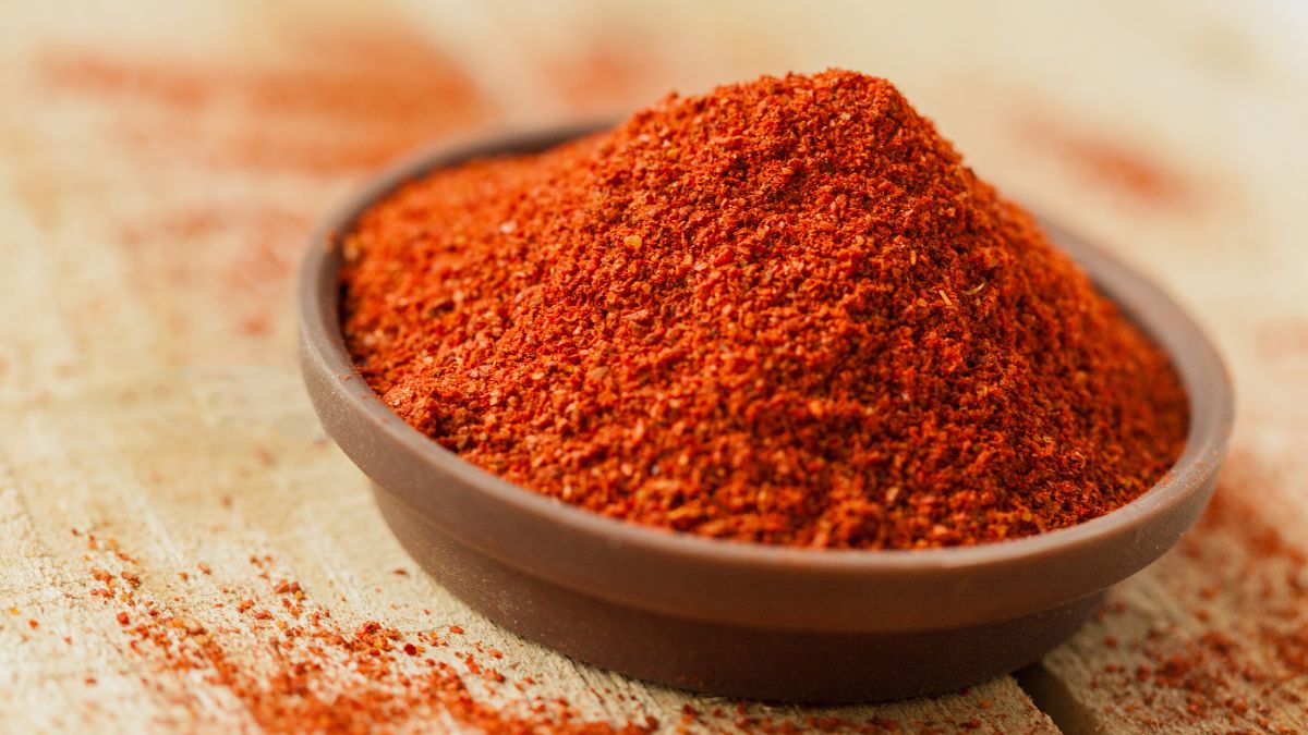 Poudre de piment de Cayenne dans un bol en terre cuite sur une table en bois.