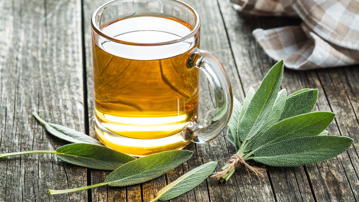 Tasse de thé de sauge sur une table en bois avec des feuilles de sauge.